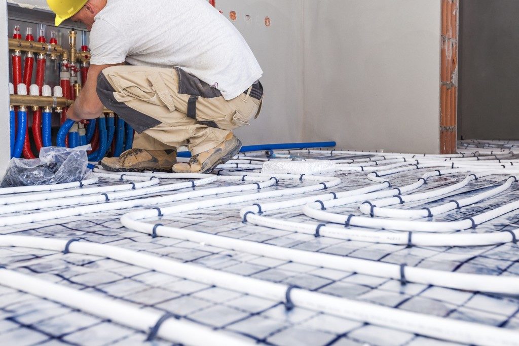 Worker installing a floor heating system