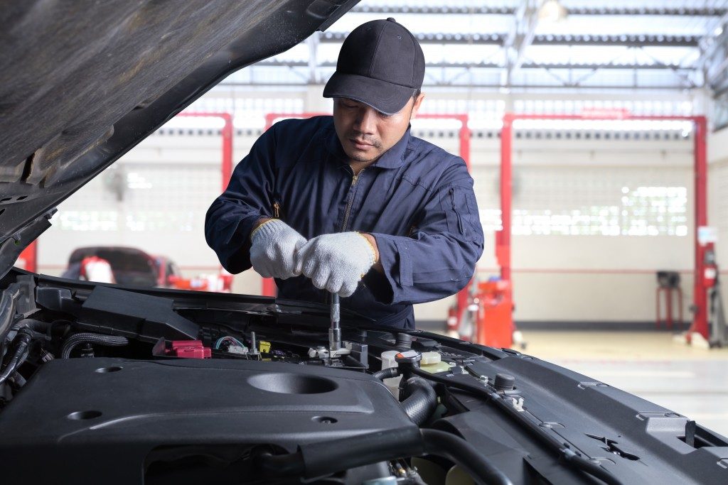 mechanic checking engine of car