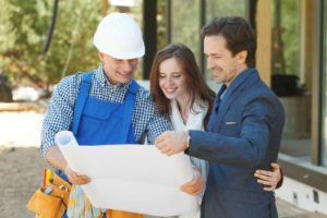 architect showing blueprints to houseowners