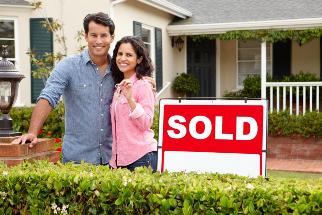 Couple in front of their newly bought house