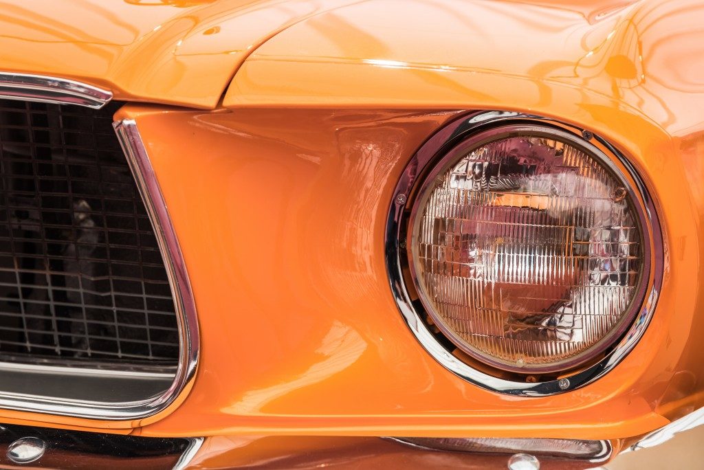 Shiny orange car closeup on headlight