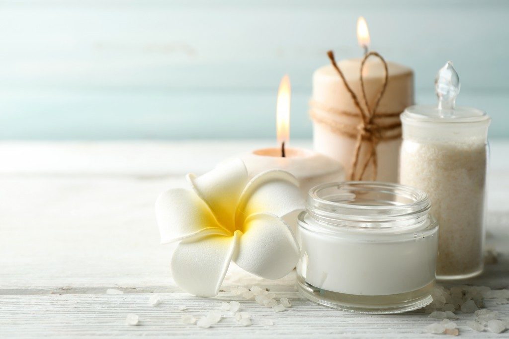 bath and spa products with candles and a flower