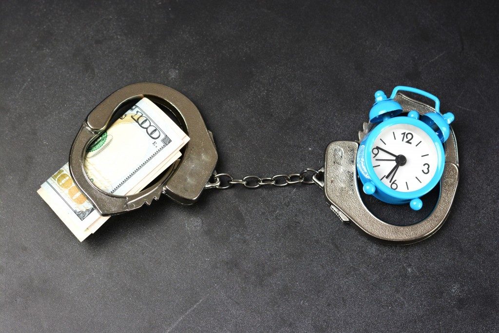bail concept, money and clock on handcuffs