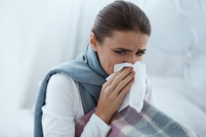 woman sneezing into a cloth