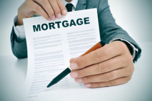 person handing a mortgage contract and a pen