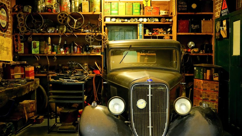 inside of garage with classic car with spare parts and tools behind