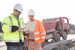 two construction workers on their laptop