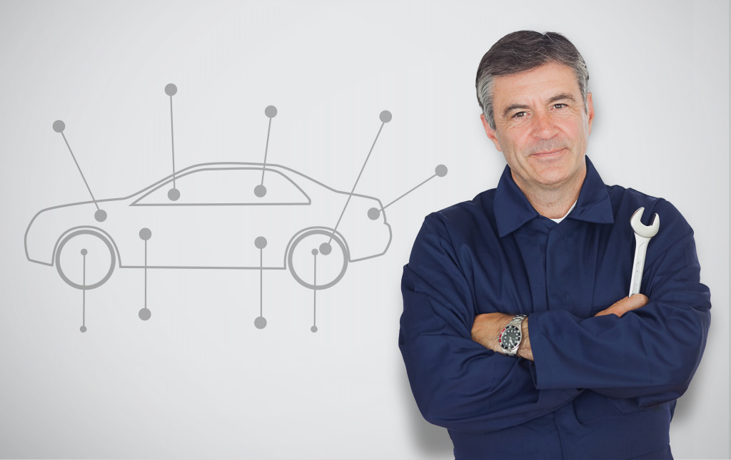 male car expert holding a tool with car drawing on board