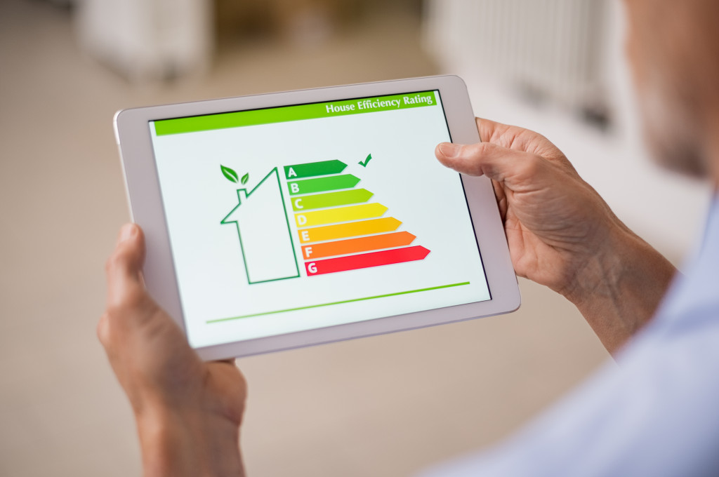 A man holding a tablet showing an energy efficiency chart